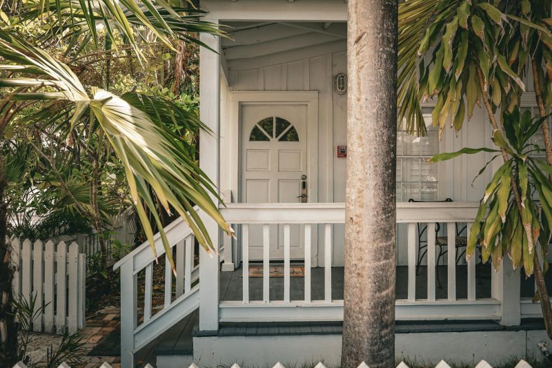Charming tropical front porch with palm trees and white wood 1772557439